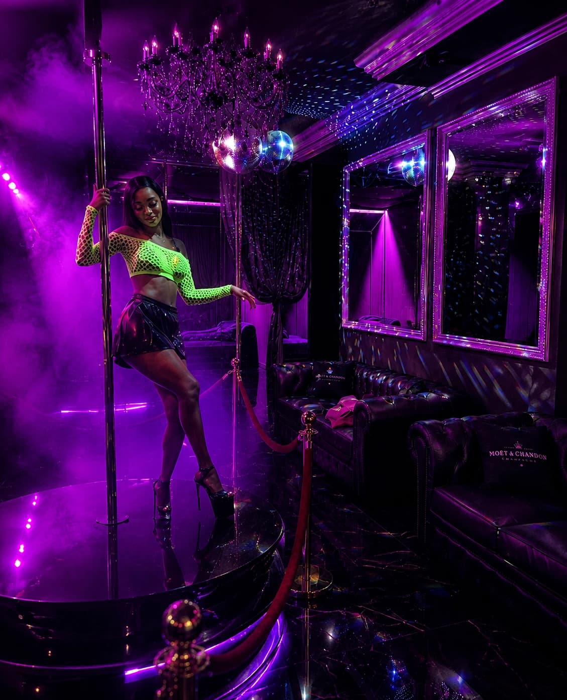 A dancer performing in an intimate purple-lit VIP lounge
